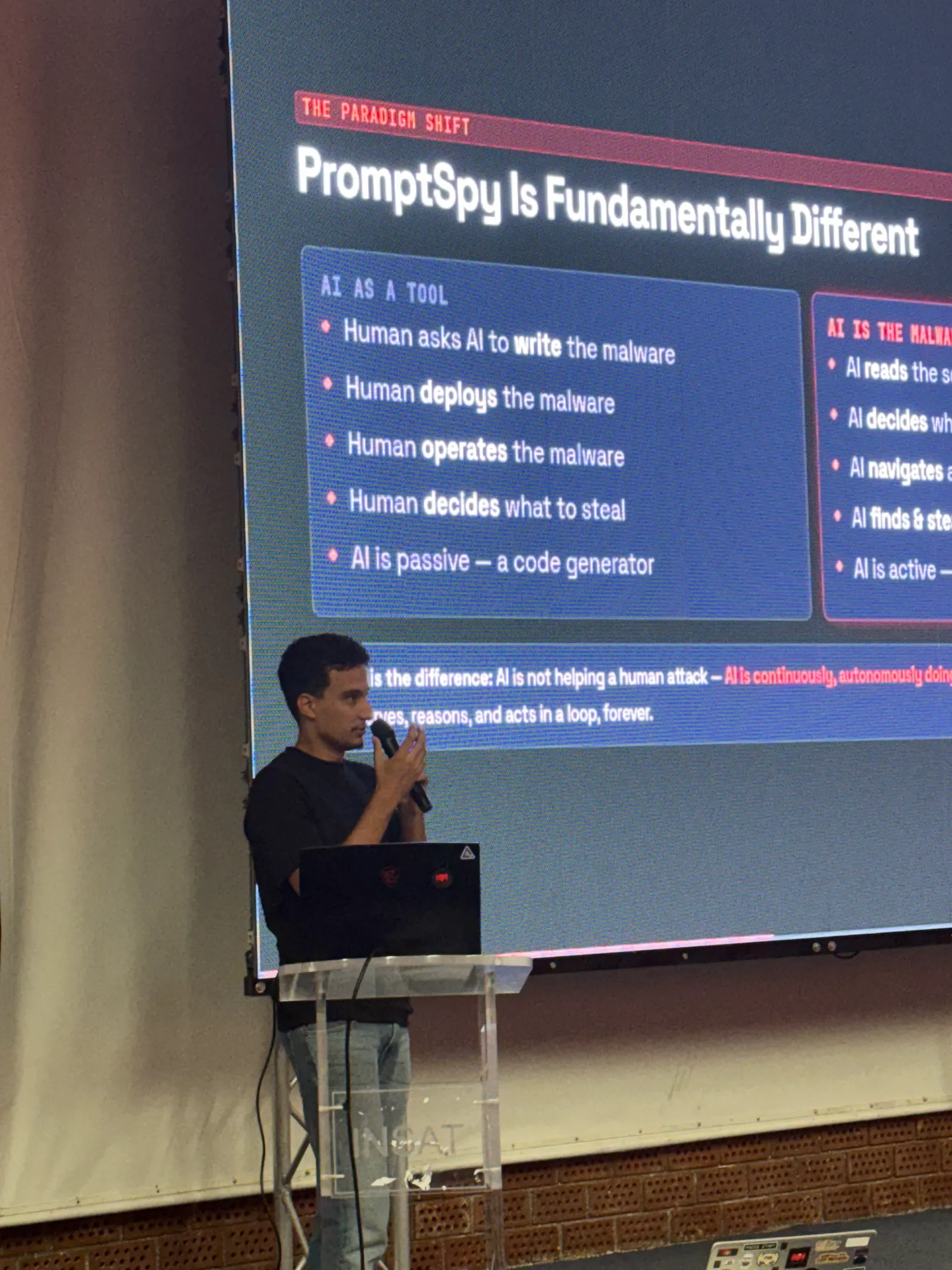 Khalil speaking at the lectern during a workshop on AI and cybersecurity.